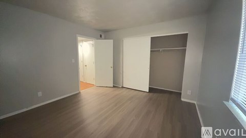 A room with a white door and a window with blinds.