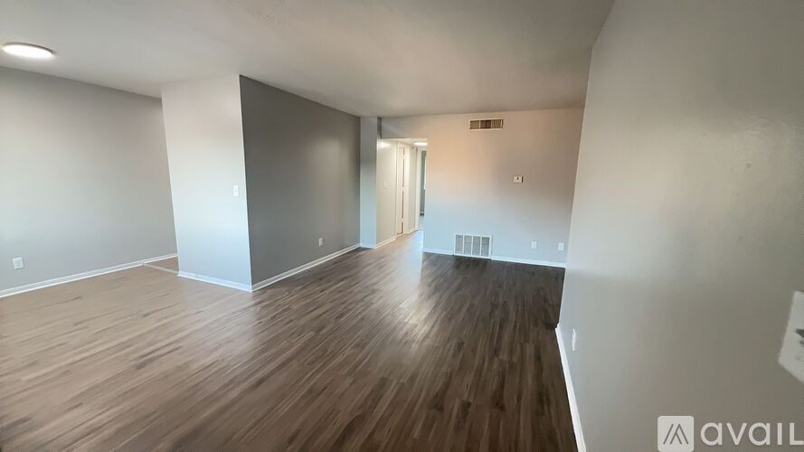 A room with wooden flooring and white walls.