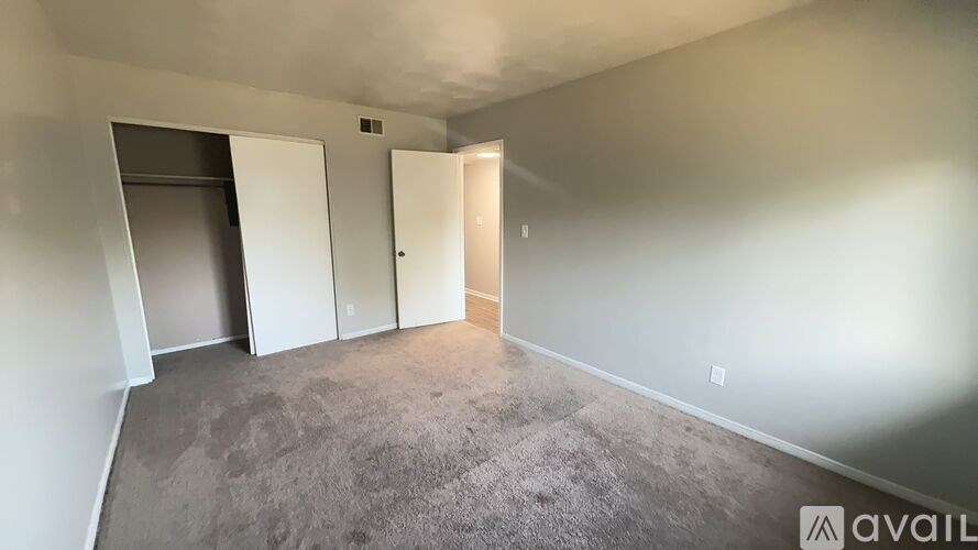 A room with a grey carpet and a white door.