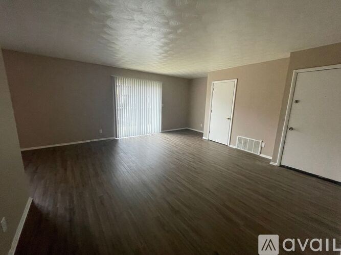 A room with wooden flooring and two white doors.