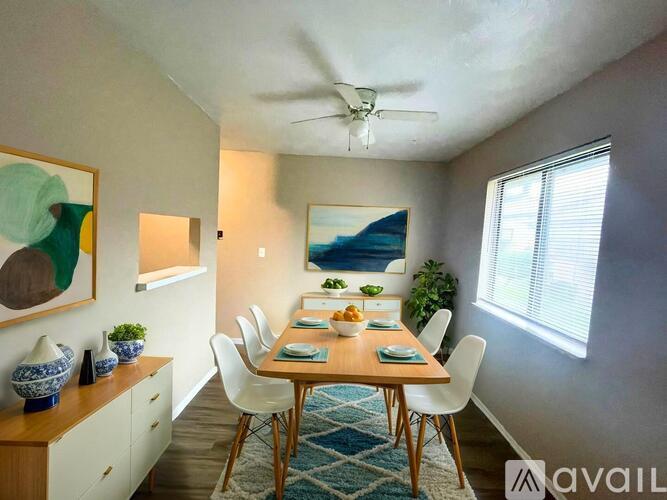 A room with a ceiling fan and a window with blinds.