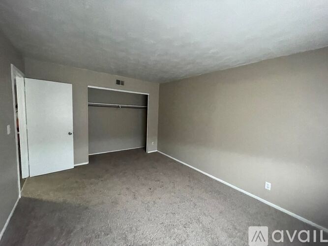 A room with a white door and a grey wall.