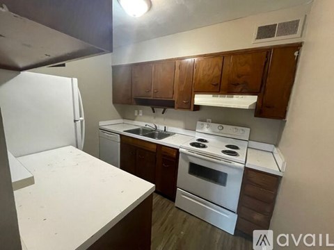 A kitchen with white appliances and wooden cabinets.