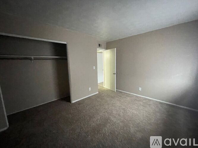 A room with a grey carpet and a white door.