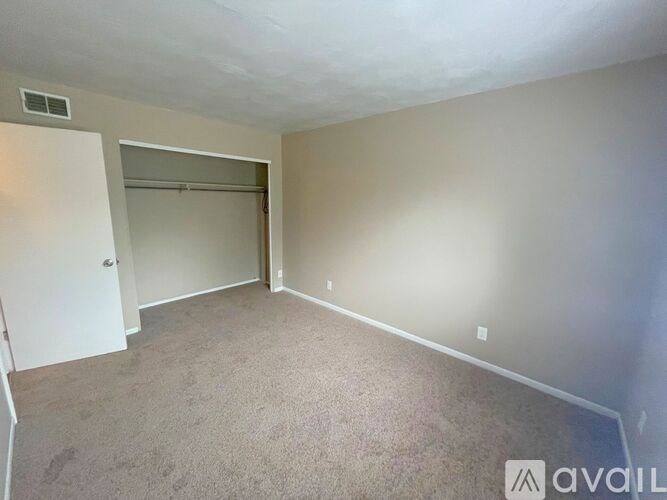 A room with a carpeted floor and a white door.