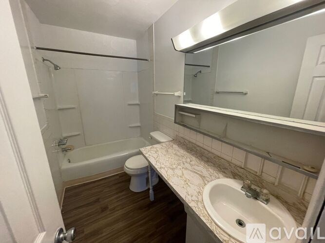 A bathroom with a toilet, sink, and bathtub.