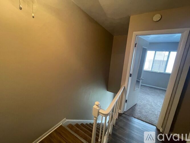 A room with a staircase leading to another room.