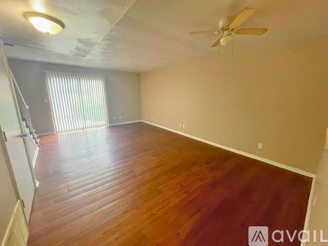 A room with wooden flooring and a ceiling fan.