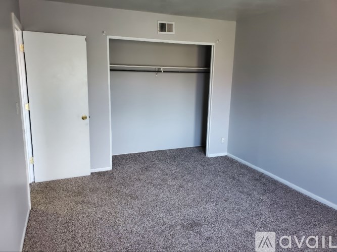 A room with a carpeted floor and a white door.