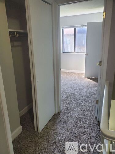 A carpeted hallway with a door on the right.
