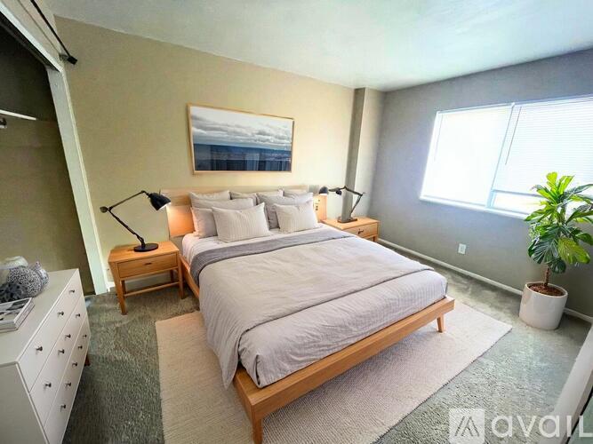A spacious room with wooden flooring and a staircase.
