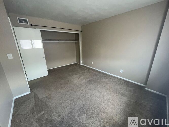 A room with a grey carpet and a white door.