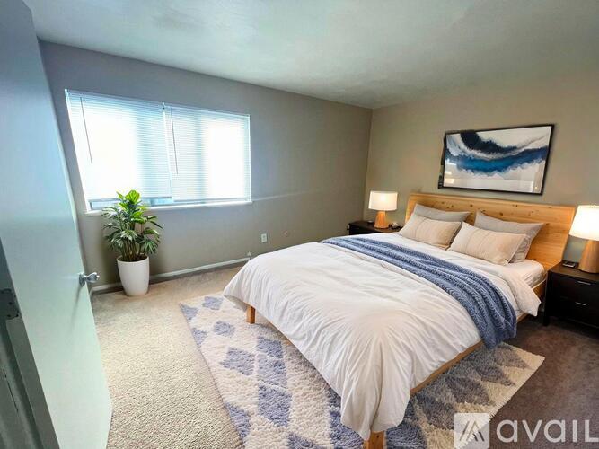 A carpeted room with a window and a door.
