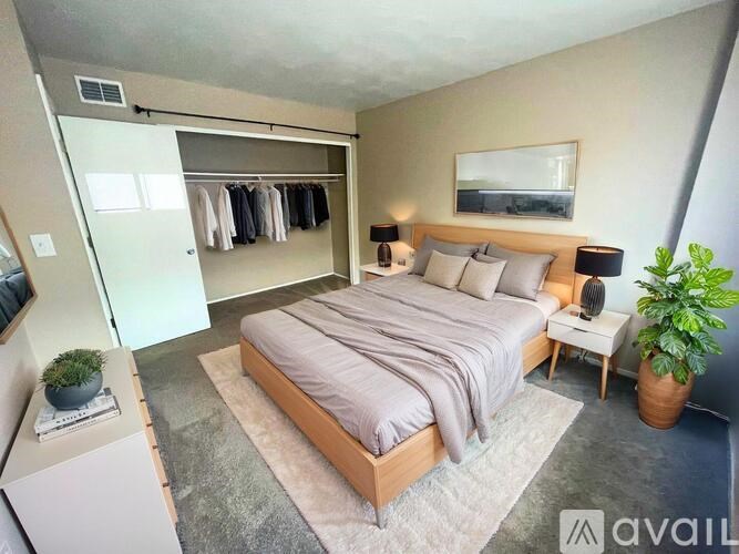 A white toilet in a small bathroom with a white tiled wall and a white sink.