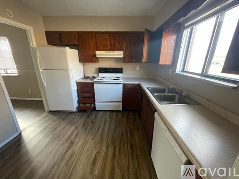 A kitchen with wooden cabinets and a white refrigerator.