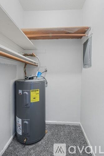 A water heater in a room with a grey floor and white walls.