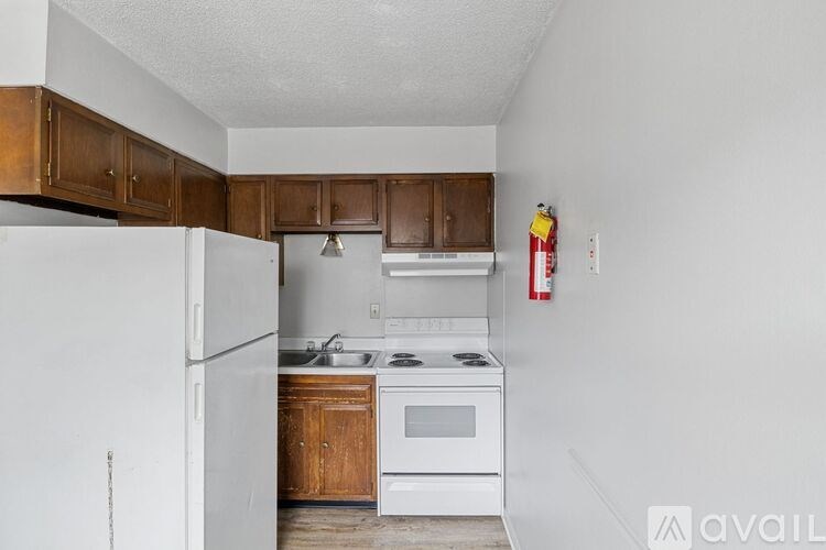 A kitchen with white appliances and wooden cabinets.