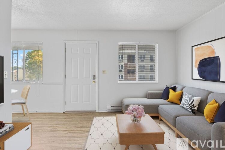 A living room with a grey couch, a coffee table, and a painting on the wall.