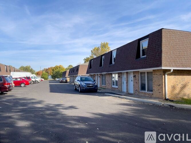 A parking lot with cars and a building with the sign "AVAIL" on it.