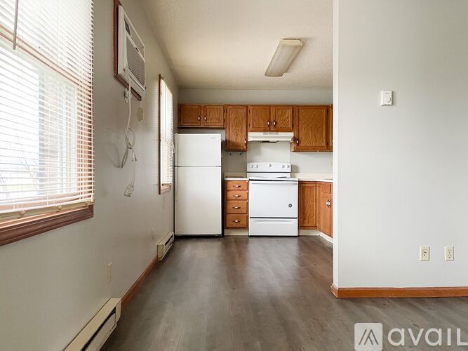 A kitchen with white appliances and wooden cabinets.