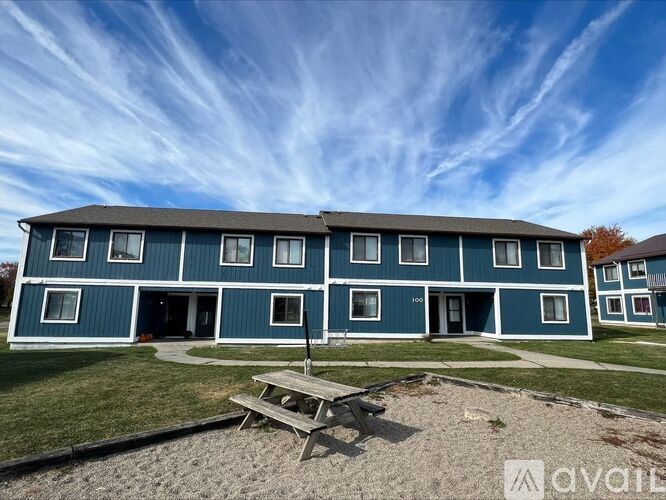 A blue building with a picnic table in front of it.