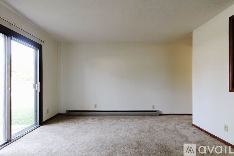 A room with a carpeted floor and a sliding glass door.