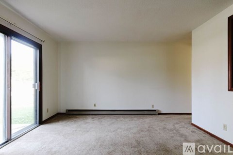 A room with a carpeted floor and a sliding glass door.