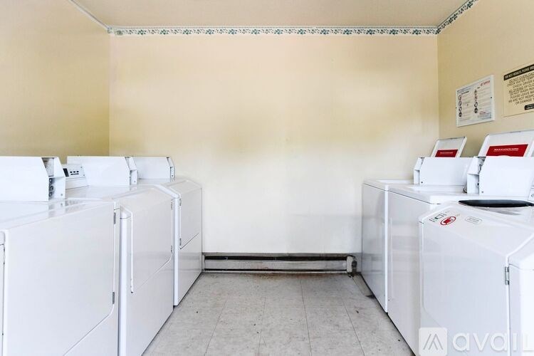 A laundry room with washing machines and a dryer.