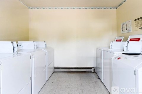 A laundry room with washing machines and a dryer.