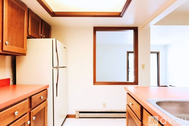 A kitchen with wooden cabinets and a white refrigerator.