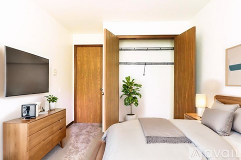 A bedroom with a bed, nightstand, and a television.