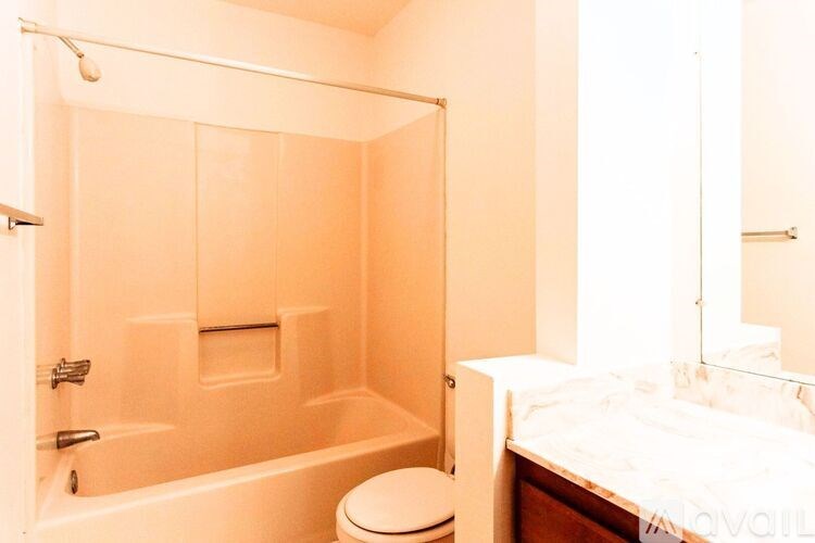 A bathroom with a toilet, a bathtub, and a bed.