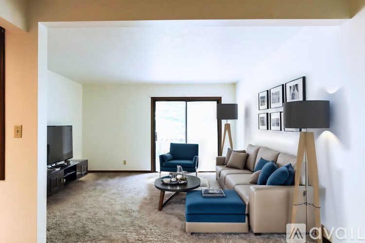 A living room with a blue chair and a brown couch.