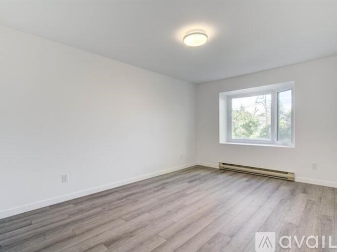 A room with a window and wooden flooring is available for rent.