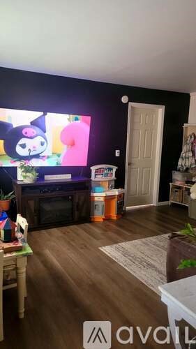 A living room with a flat screen TV and a white door.