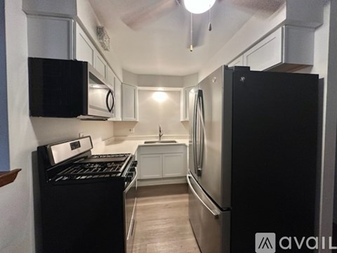 A kitchen with a refrigerator, sink, and cabinets.
