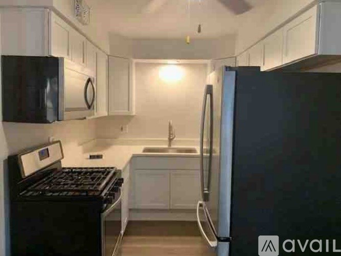 A kitchen with black appliances and white cabinets.