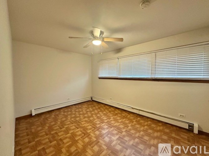 A room with a ceiling fan and wooden flooring.