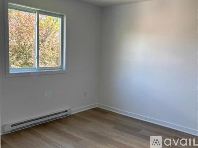 A room with a window and a wall-mounted heater.