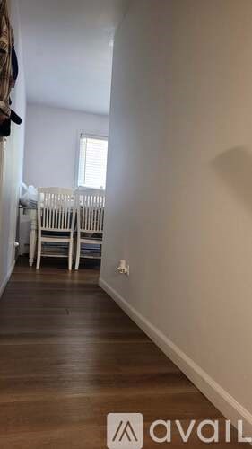 A room with a wooden floor and a white wall.