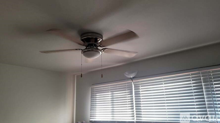 A ceiling fan is hanging from the ceiling in a room.