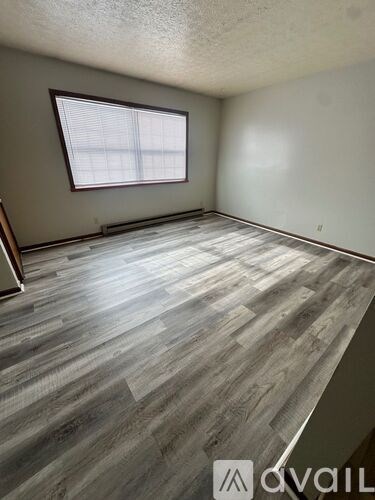 A room with wooden flooring and a window.
