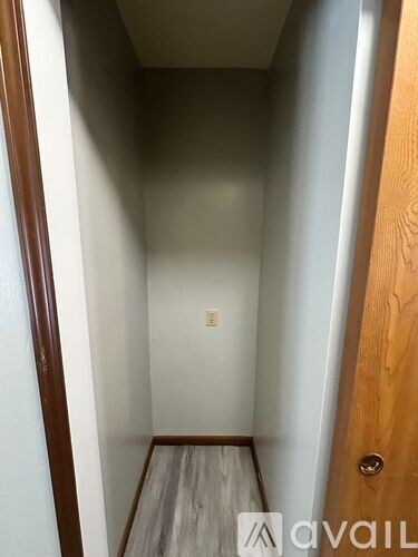 A narrow hallway with wooden floors and white walls.