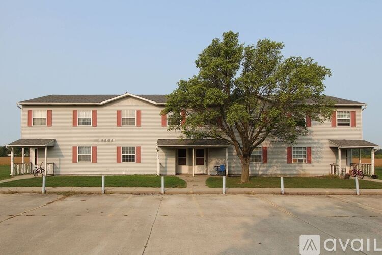 A two-story house with a tree in front.