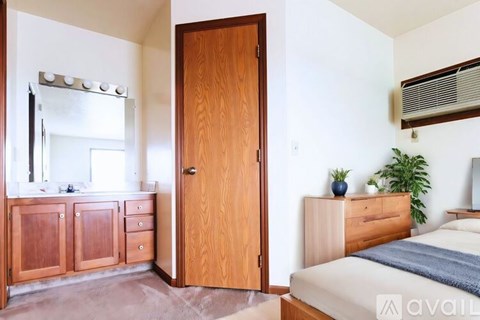 A bedroom with a bed, dresser, and mirror.