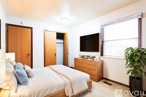 A bedroom with a bed, nightstand, and a window.
