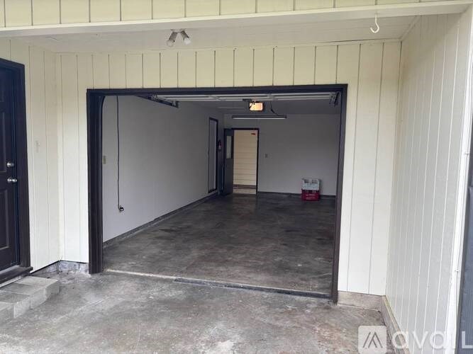 A room with a black door and a white wall with a black frame.