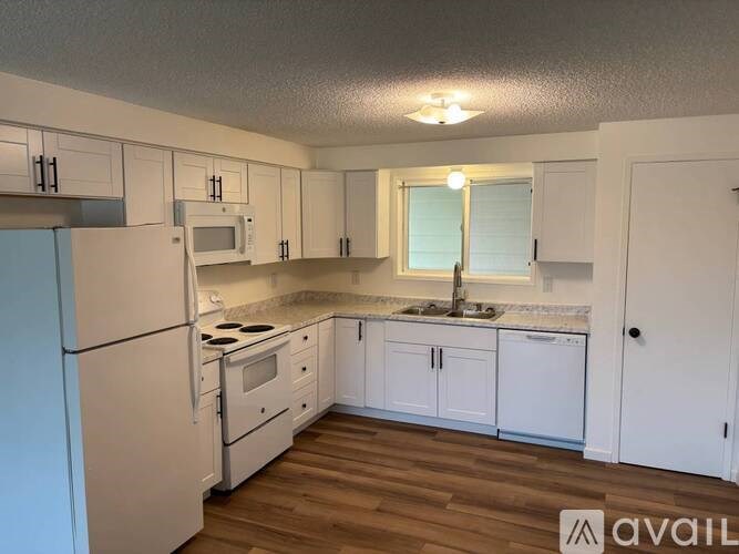 A kitchen with white appliances and cabinets.