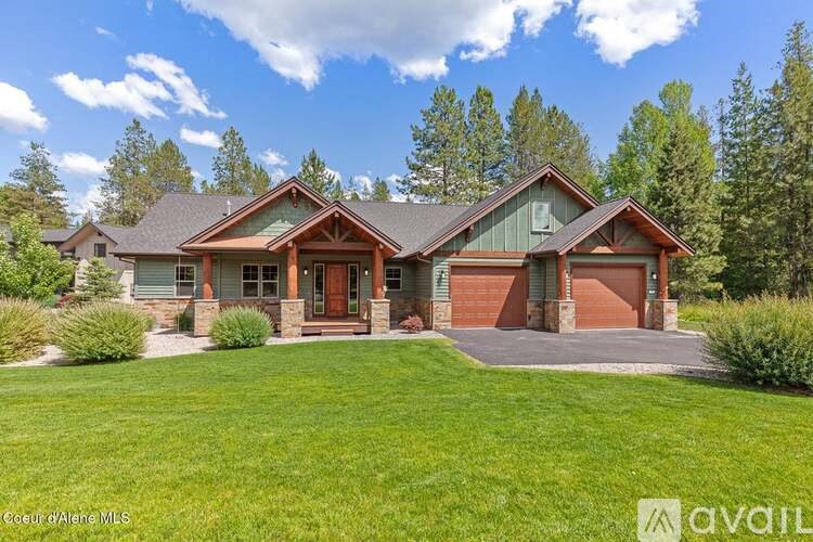 A house with a green lawn and trees in the background.