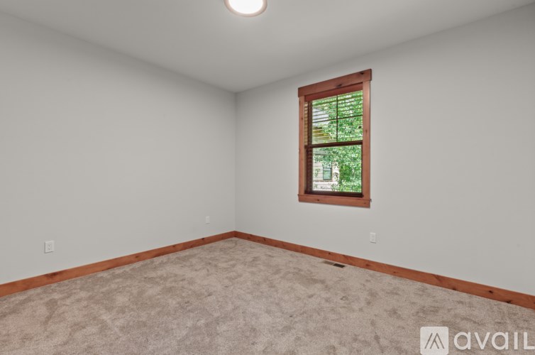 A room with a window and carpeted floor.
